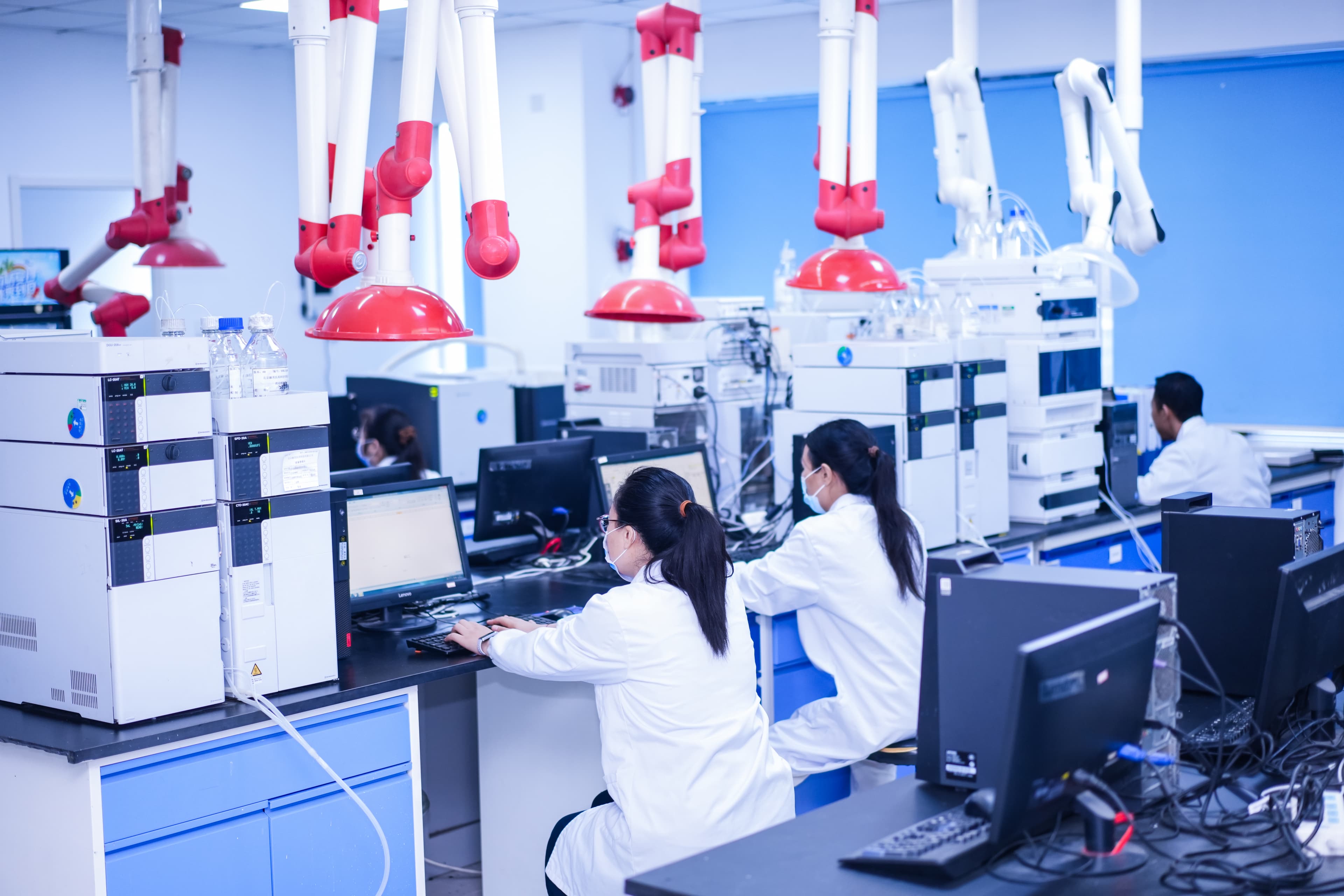 Researchers working at laboratory instruments and computers